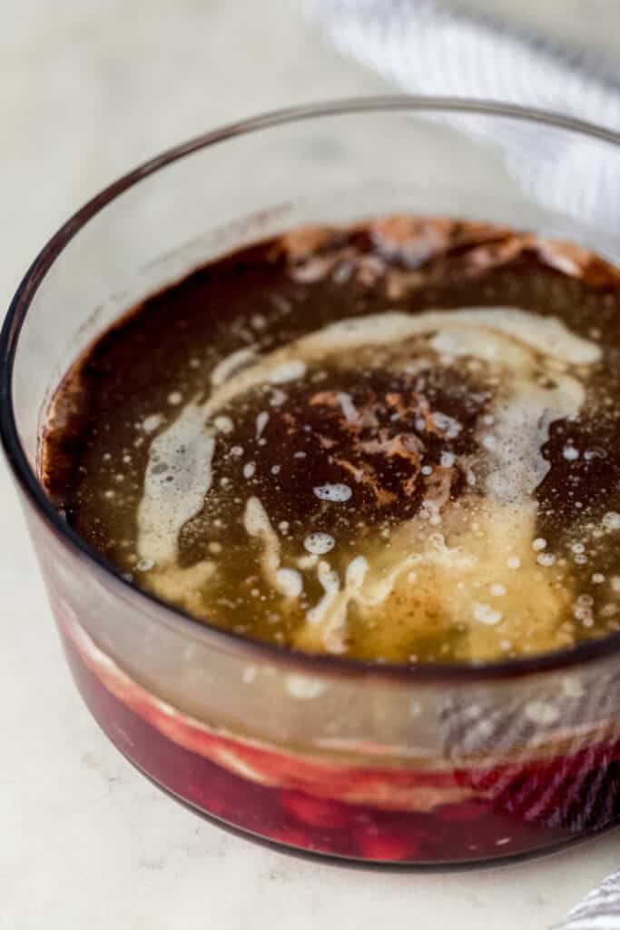 melted butter poured over chocolate cake mix in glass dish for dump cake