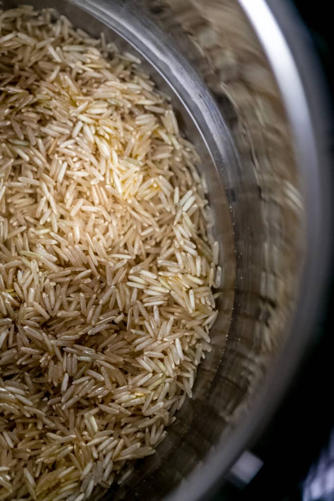 ingredients for instant pot brown rice stirred together in the pressure cooker