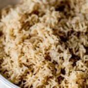 Close up view of bowl of finished brown rice on pin with text overlay.