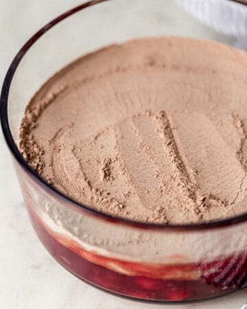 Cake mix added to cherry filling in baking dish.