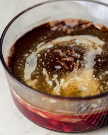 Melted butter added to glass dish with other ingredients.