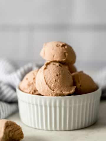 side view chocolate fat bombs stacked in small white bowl