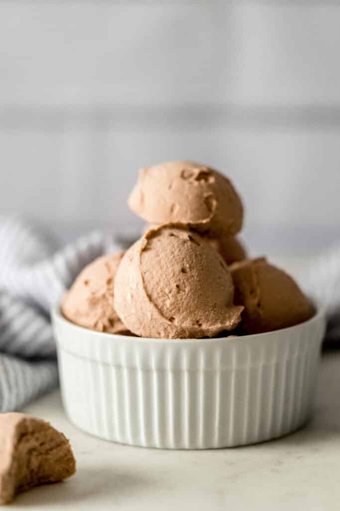 side view chocolate fat bombs stacked in small white bowl