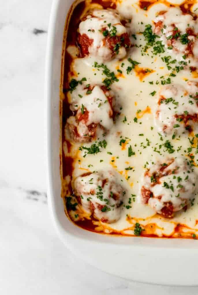 finished meatball casserole topped with chopped parsley in baking dish