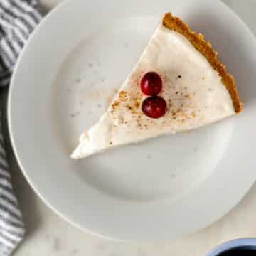 overhead view piece no bake eggnog cheesecake on small white plate