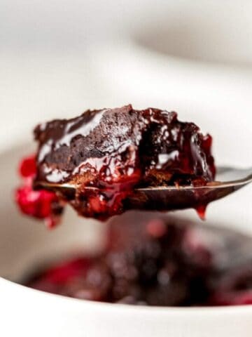 instant pot chocolate cherry dump cake on spoon being held by hand