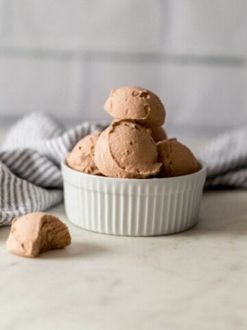 keto chocolate fat bombs stacked in a white bowl with a napkin
