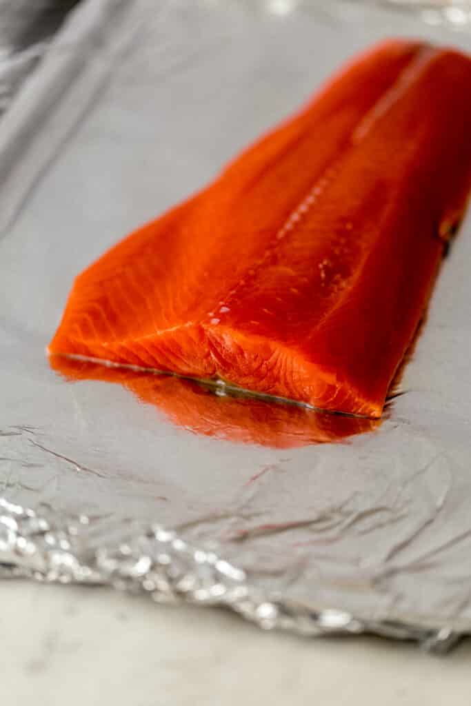 whole salmon on aluminum foil lined sheet pan