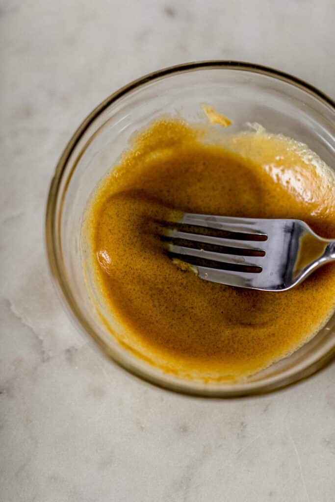 small glass bowl with brown sugar and Dijon mustard mixed together with fork