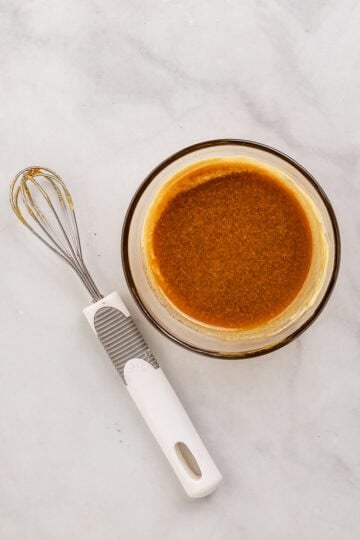Glaze ingredients combined in small glass bowl by whisk.