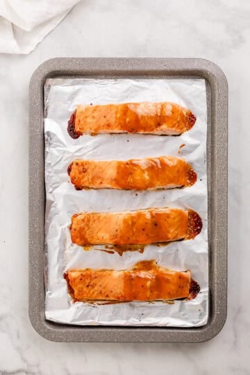Baked salmon on foil lined sheet pan.