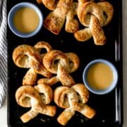 Overhead view of pretzels on sheet pan with sauce.