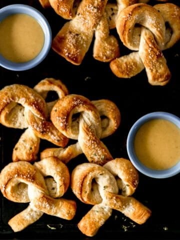 Overhead view of pretzels on sheet pan with sauce.