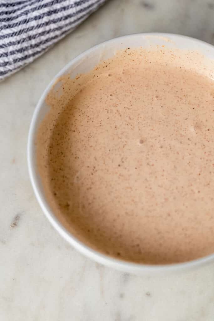 ingredients for yum yum sauce mixed together in white bowl