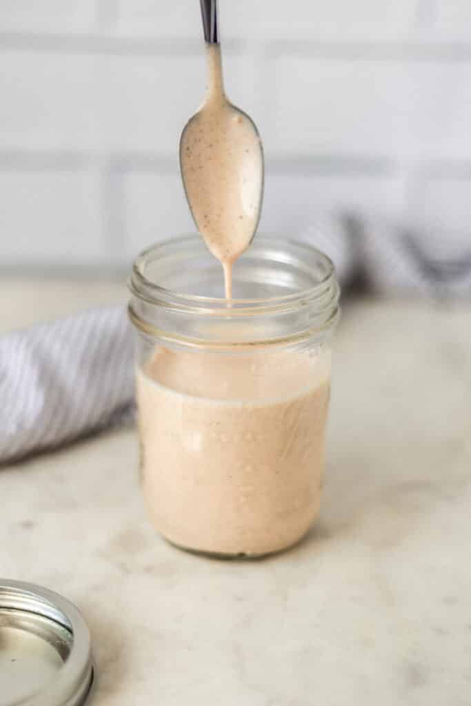 side view yum yum sauce in glass jar with spoon