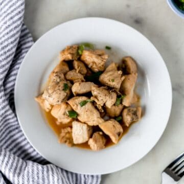 hibachi chicken on white plate next to fork and cloth napkin