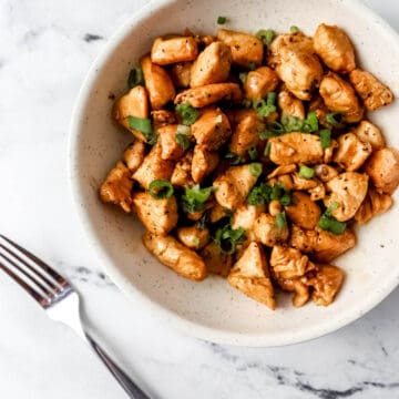 Overhead view of finished hibachi chicken in a white bowl by a fork.