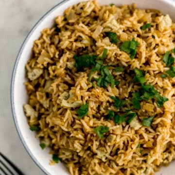 large white bowl of hibachi rice next to a fork and napkin