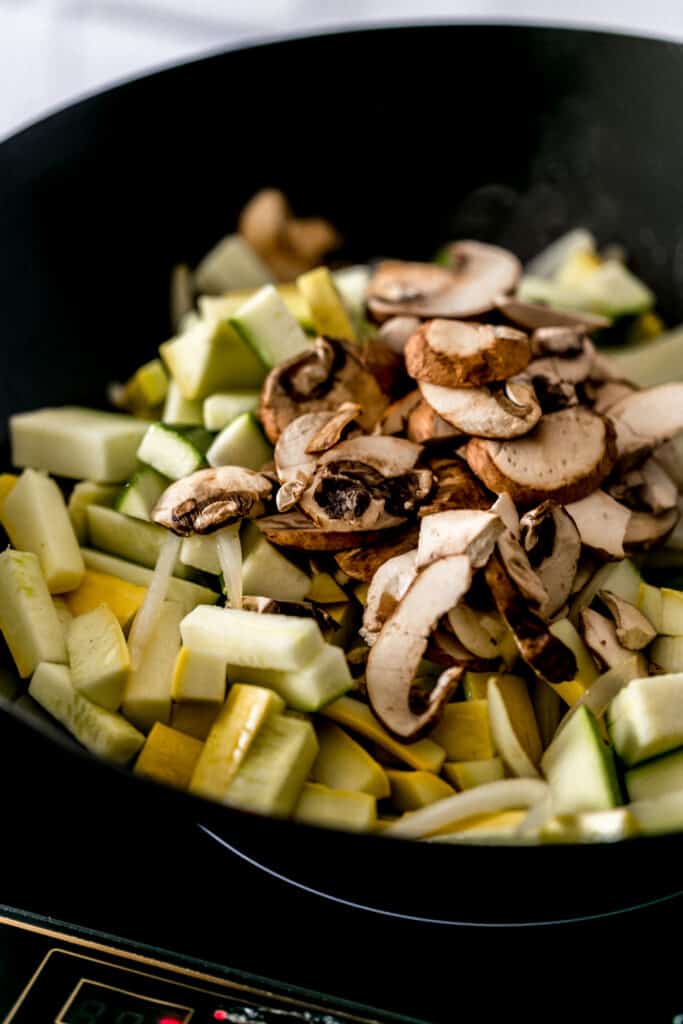 uncooked chopped vegetables piled into a wok