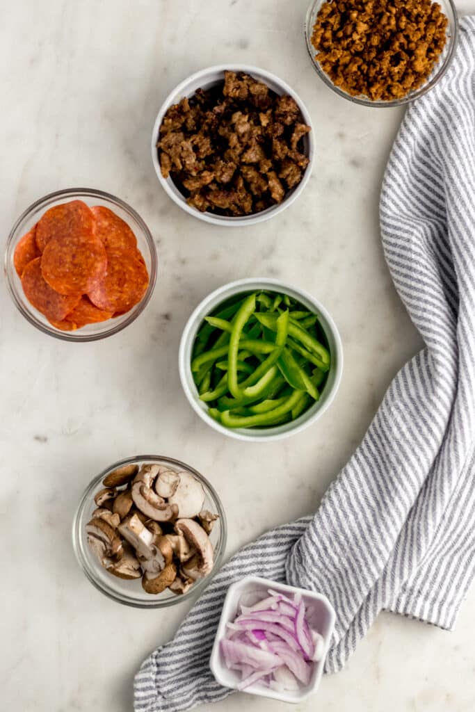 toppings for homemade supreme pizza in small bowls 