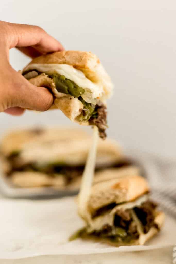 hand holding half of cheesesteak 