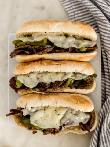 overhead view instant pot philly cheesesteaks on white square plate with napkin