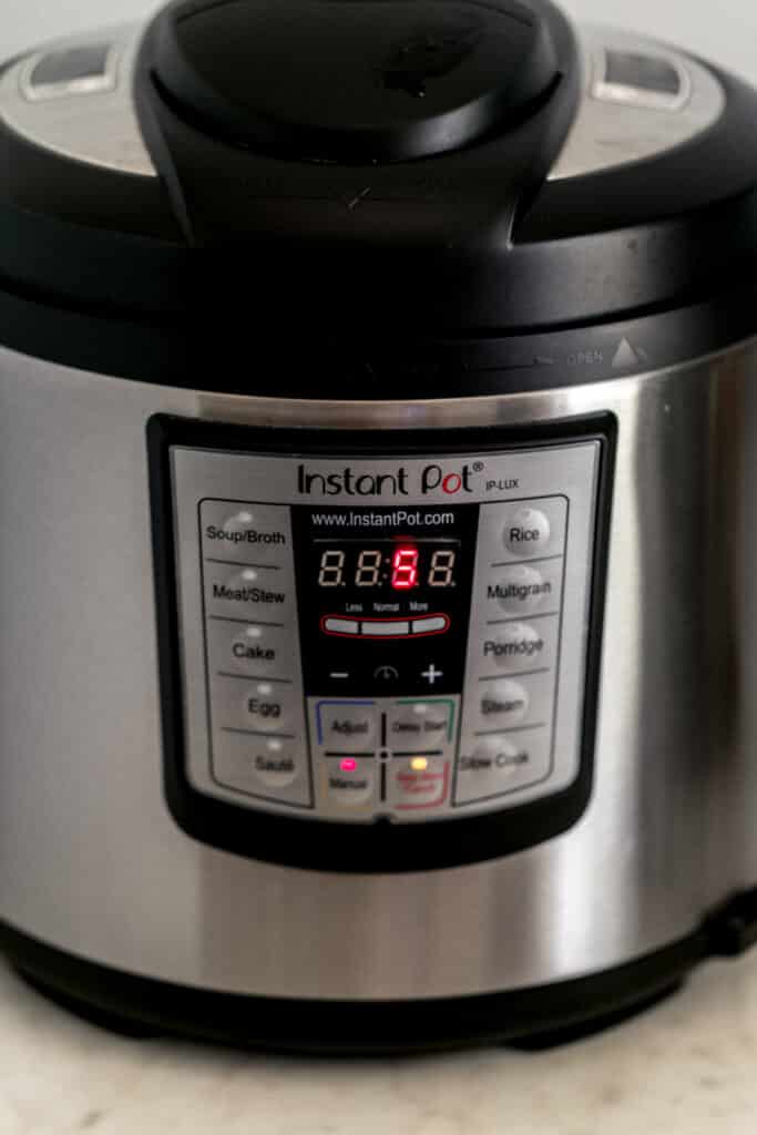 side view instant pot pressure cooker set to five minutes cooking time