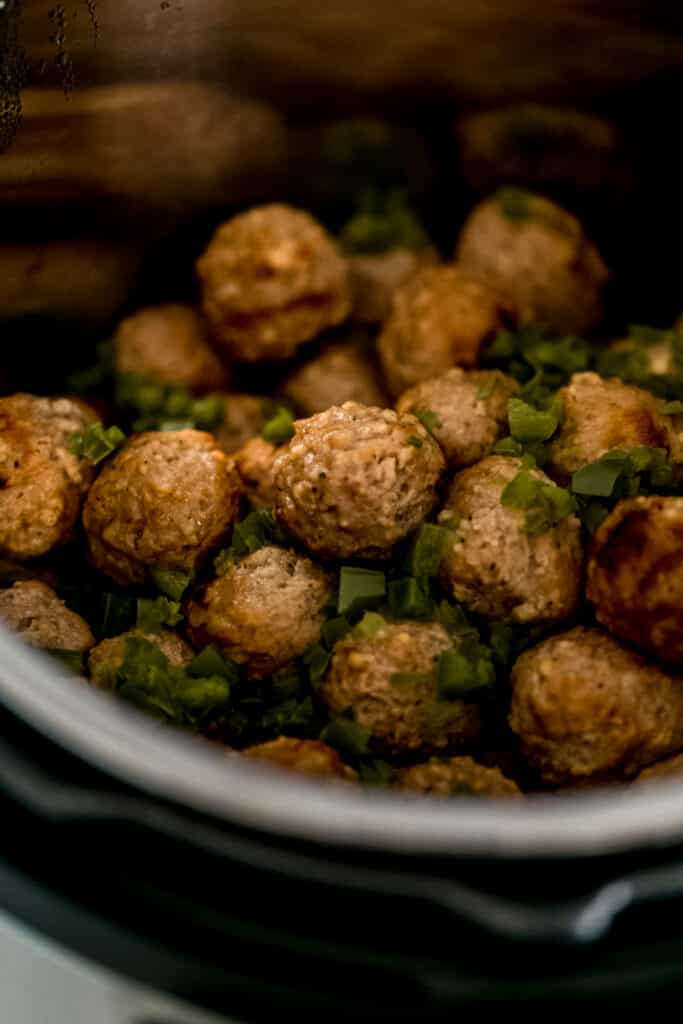 cooked meatballs and diced jalapenos in pressure cooker 