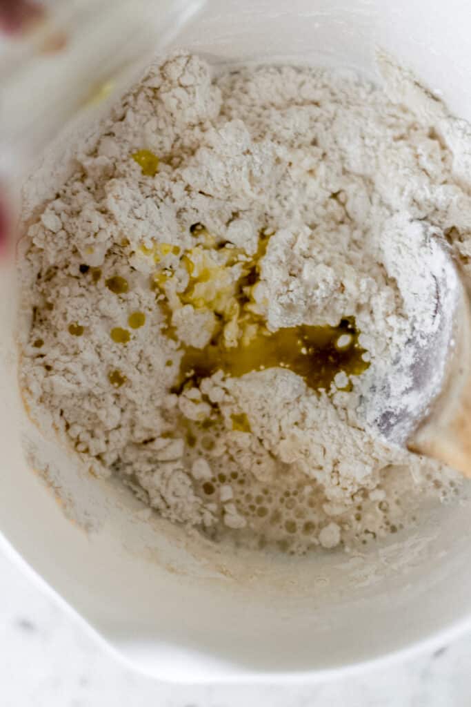 olive oil adding to mixing bowl to make yeast free pizza dough