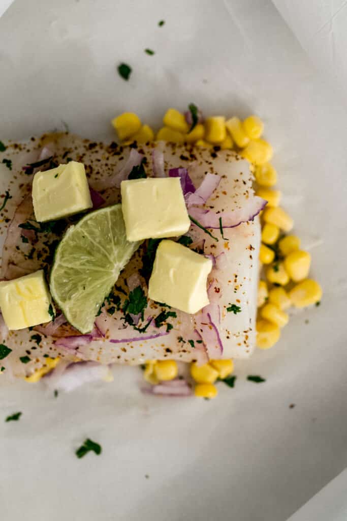 cod, corn, red onion, butter, lime on parchement paper