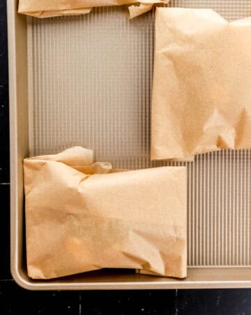 Close up view of parchment packets on sheet pan.