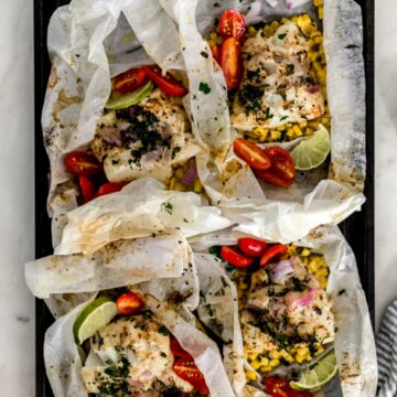 overhead view of finished fish in parchment paper on baking sheet