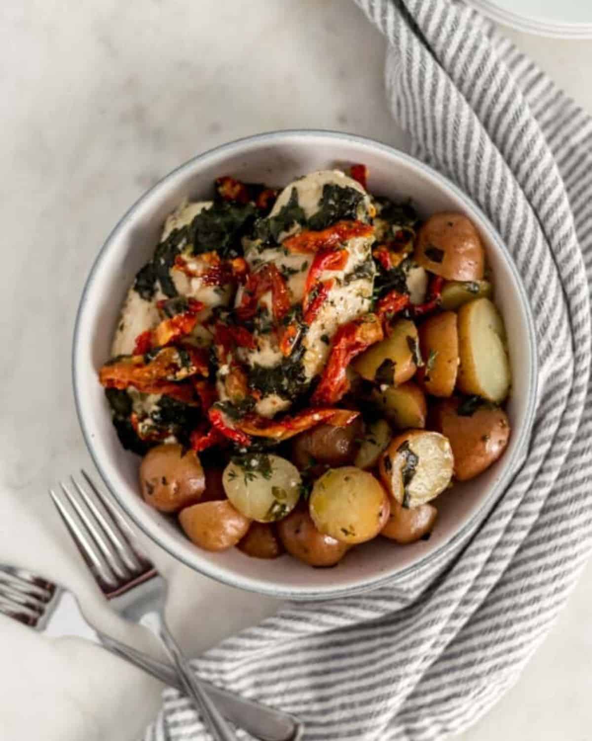 Overhead view of bowl of finished chicken and potatoes.