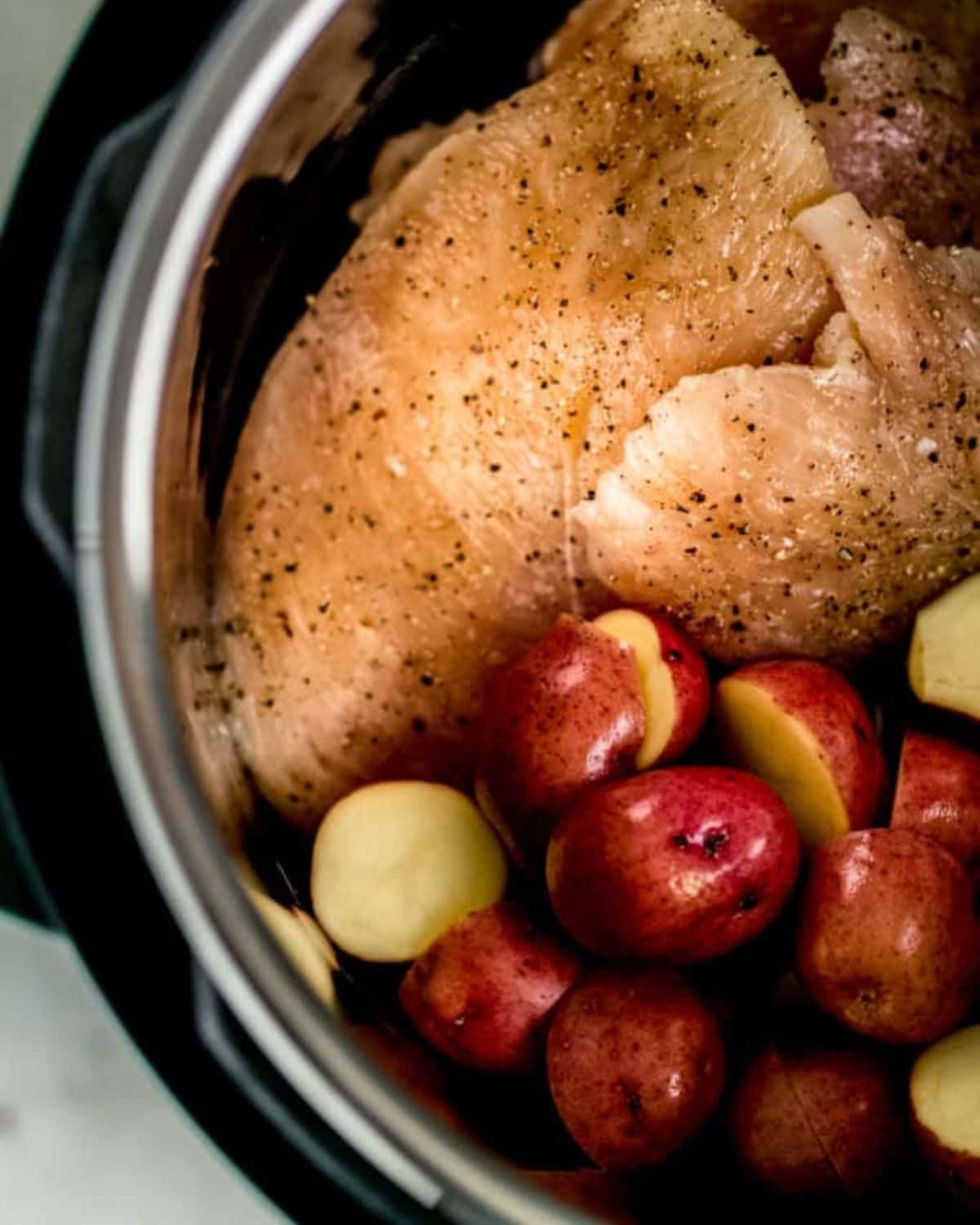 Seasoned chicken and potatoes added to instant pot.