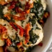 Close up serving of sun dried tomato chicken and potatoes in bowl.