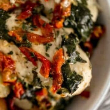 Close up serving of sun dried tomato chicken and potatoes in bowl.