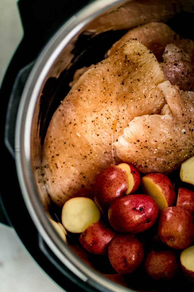 raw chicken and red potatoes in a pressure cooker 