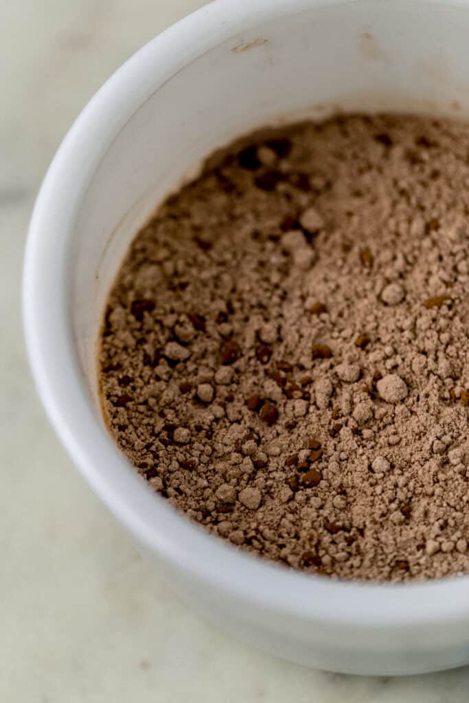 flour and cocoa powder mixture for chocolate sugar cookies in a white mixing bowl 