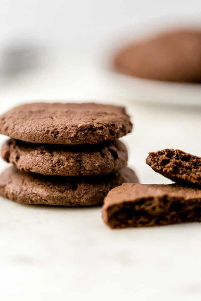 stack of three chocolate sugar cookies with a single cookie split in half on the side 