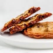 Close up view of two cookies on a plate with one broke in half.