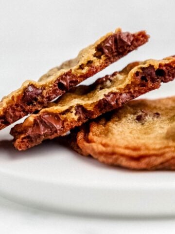 Close up view of two cookies on a plate with one broke in half.