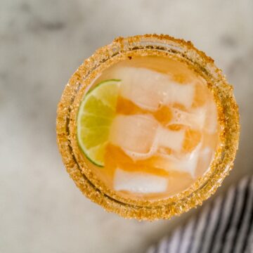 overhead view kombucha margarita with lime and ice in sugar rimmed glass.