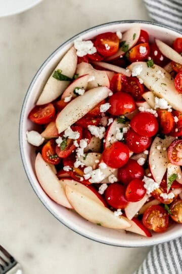 Overhead view of finished salad in a white serving bowl.