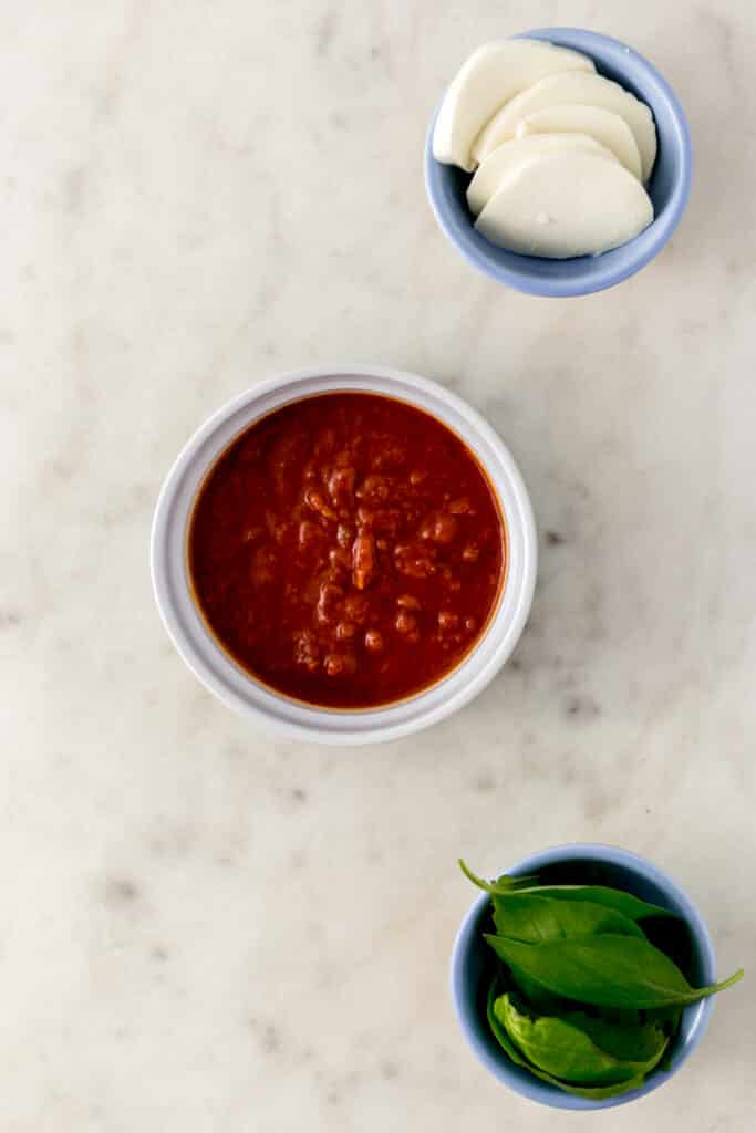 three small bowls with ingredients to make margherita pizza 