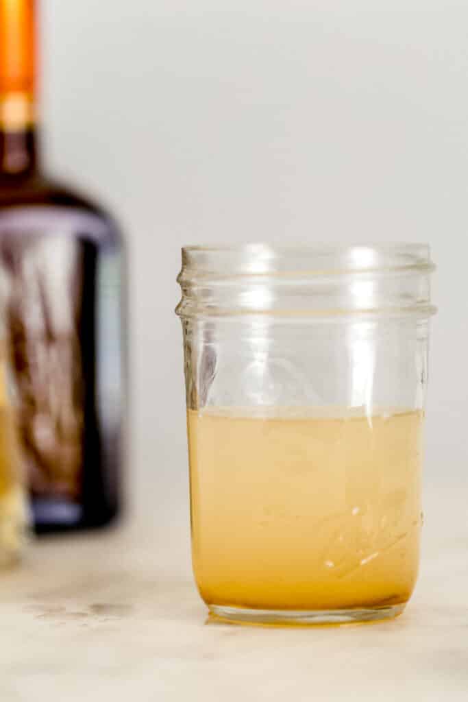 close up side view small jar with ingredients for margarita in it