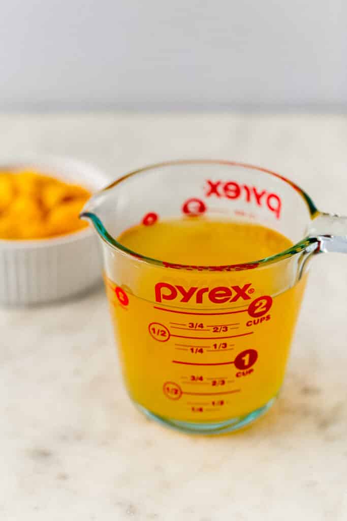 close up side view strained peach syrup for tea in pyrex pitcher 