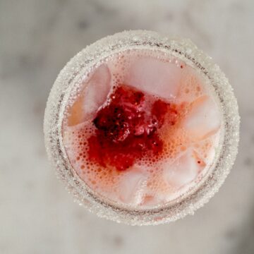 overhead view sugar rimmed glass with strawberry margarita in it.