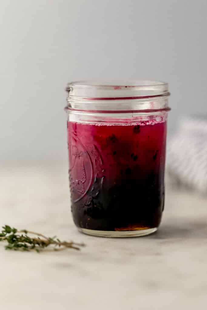 close up side view glass jar with ingredients for blackberry margarita in it. 