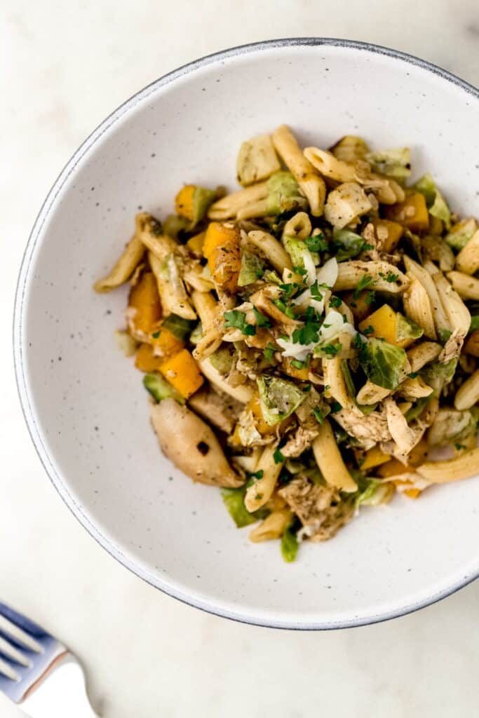 overhead view of single pasta serving in white bowl next to fork