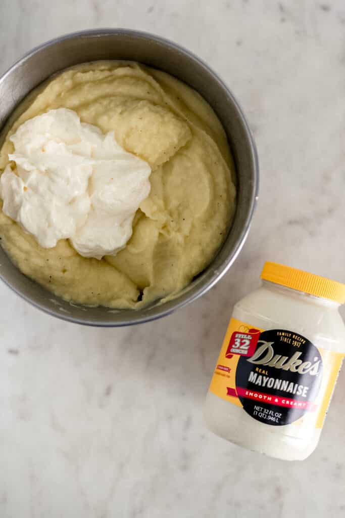 mayo added to other ingredients in stand mixer bowl next to jar of mayo